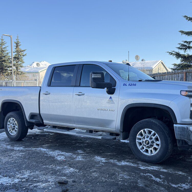 Silver work pickup parked in the snow